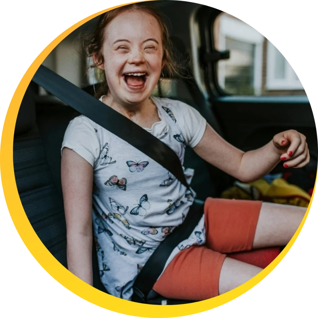smiling girl with disability sitting in a car