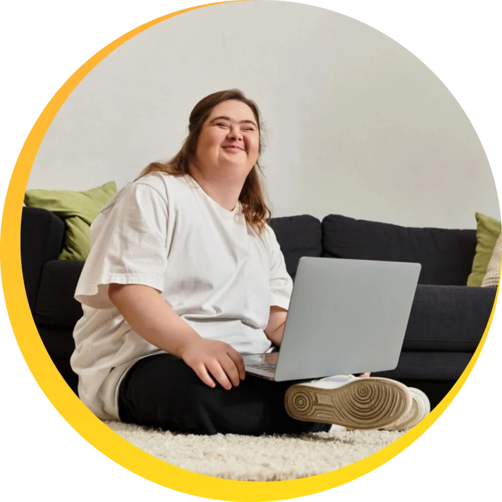 A woman with down syndrome using laptop and smiling